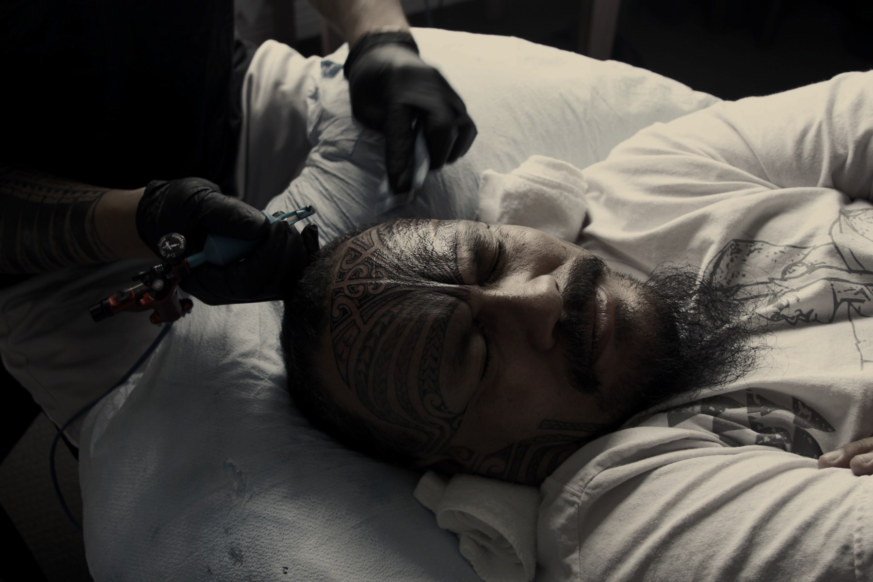 The sacred tatau artist tattooing a facial moko onto the Ali'i Nui in Aotearoa
